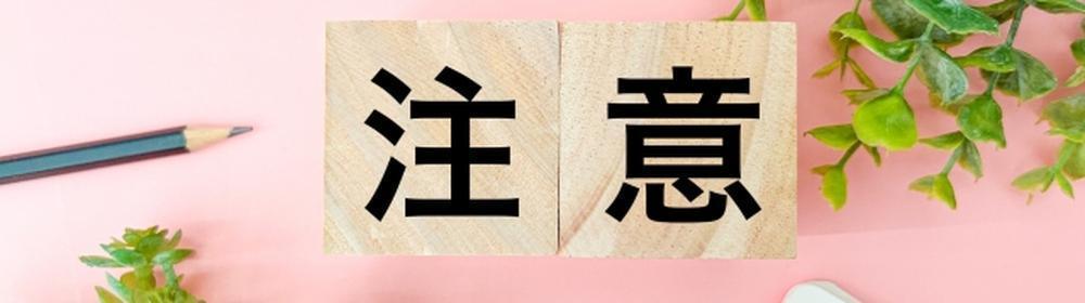『注意』の文字と観葉植物・チェックリストが並ぶデスク